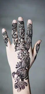 Intricate henna design on a hand with light gray background.