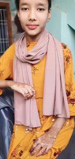 Girl wearing floral dress with henna designs on her hands.