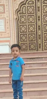 Child standing on steps by ornate heritage door.