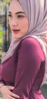 Elegant woman in maroon dress and hijab outdoors.