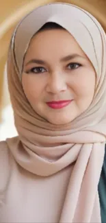 Portrait of a woman wearing an elegant hijab with a beige background.