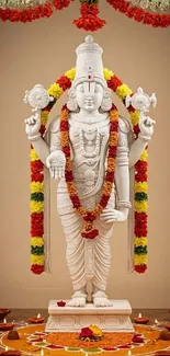Hindu deity adorned with garlands and traditional lamps.