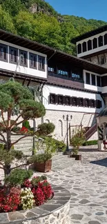 Historic building with greenery and flowers on a sunny day.