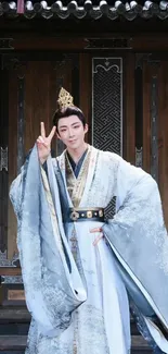 Person in historical attire posing in front of ornate wooden doors.