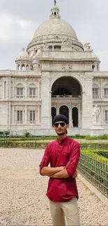 Man standing in front of historical building with dome and arches.