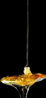 Luxurious honey drip on a spoon against a black background wallpaper.