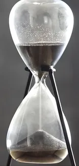 Elegant hourglass with gray sand against a soft background.