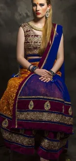 Woman in colorful Indian traditional attire sitting elegantly.