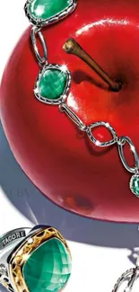 Mobile wallpaper of jewelry draped over a red apple with green gemstones.