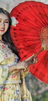 Woman in floral kimono with red parasol outdoors.