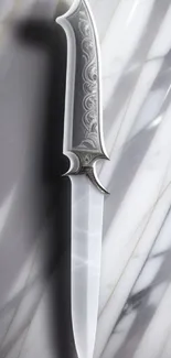 Elegant knife on a marble background, perfect for mobile wallpaper.