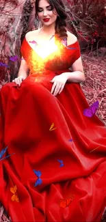 A lady in a vibrant red dress sits elegantly against a natural backdrop.