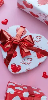 Heart-shaped gift boxes with a pink background, perfect for love and romance themed wallpaper.