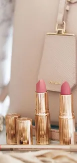 Elegant display of pink lipsticks and beige handbag.