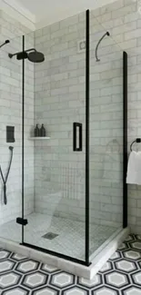 Elegant marble bathroom with glass shower and geometric tiled floor.