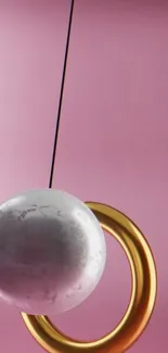 Marble orb with gold ring on pink background.