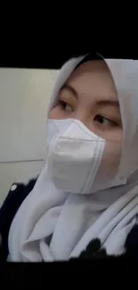 Elegant portrait of a masked woman in a white hijab.