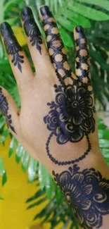 Beautiful mehndi design on hand with green leaves background.