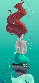 Mermaid with flowing red hair amid a blue-green sea backdrop for mobile wallpaper.