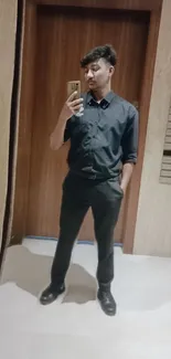 Stylish mirror selfie with a man in formal attire against a wooden background.