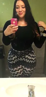 A woman taking a fashionable mirror selfie in a stylish outfit.