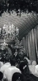 Black and white wedding scene with chandelier.