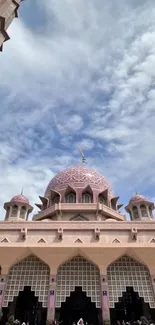 Elegant mosque with intricate dome under a bright blue sky.