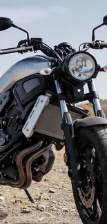 Sleek modern motorcycle parked in the sunny desert landscape.