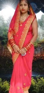 Woman in vibrant saree standing in lush natural cave setting.