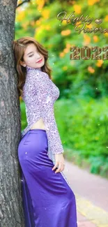 Elegant woman in purple dress by a tree with nature backdrop.