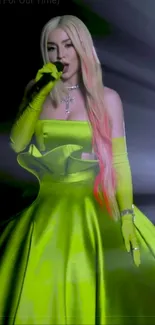 Performer in neon green dress on stage with radiant lighting.