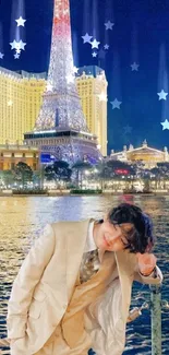 Man in suit by illuminated tower with night sky and water reflection.