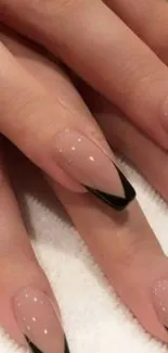 Elegant nude nails with black accents on a mobile wallpaper.