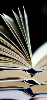 Stack of open books with turning pages in a neutral beige tone.