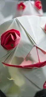 Intricate origami design with pink roses on a white background.