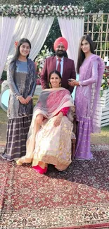 Elegant outdoor family portrait with floral decor and lush garden setting.