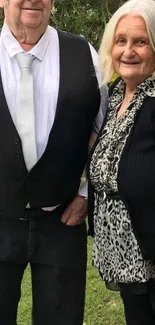 Senior couple in formal attire outdoors.