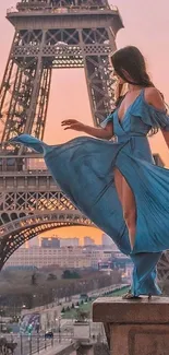 Woman in blue dress before Eiffel Tower at sunset.