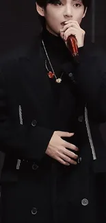 Elegant performer in black outfit holding a microphone.