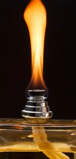 Perfume bottle with a flame on a black background.