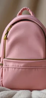 A stylish pink backpack on a soft background.