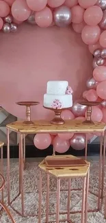 Pink balloon arch with elegant decor setup.