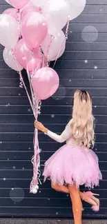 Woman with pink balloons against dark wall background.