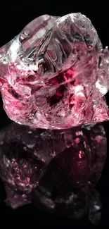 Pink crystal with reflection on black background.