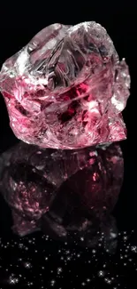 Shimmering pink crystal on reflective black background.