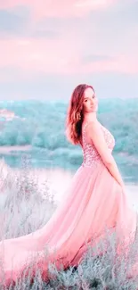 Woman in elegant pink dress by a serene lake.