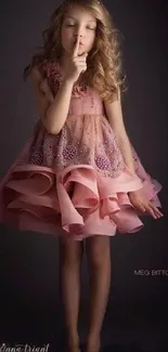 Young girl in elegant pink dress posing gracefully.