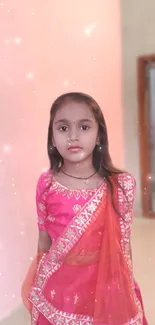 Young girl in pink ethnic attire with soft glow and sparkles.