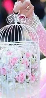 Elegant pink dress holding floral bird cage.