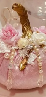 Soft pink floral decoration with pearls and golden stem.